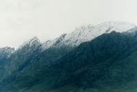 Snowy peak against cloudy sky