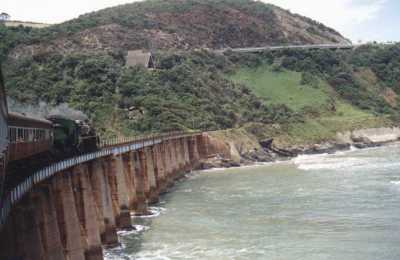 steam train crossing bridge over river